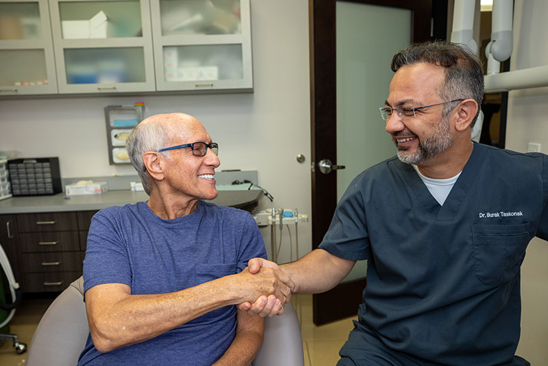 Dr. Burak Taskonak greeting a Dental Implant Patient after his all-on-4 procedure